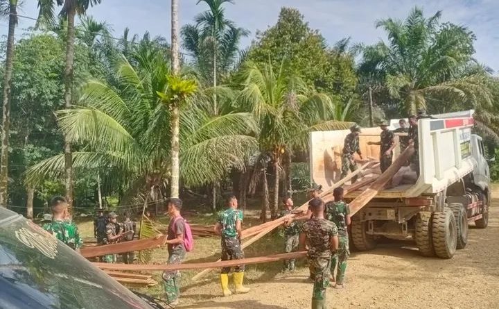 Semangat Anggota Satgas TMMD Muat Semen Dan Kayu Ke Lokasi Pembangunan Plat Beton